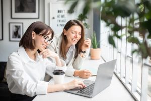 How a Clean Office Can Boost Productivity | two women laughing at their desk