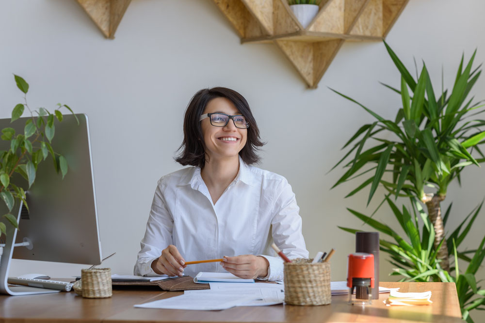 How a clean office can boost productivity | happy woman at her desk