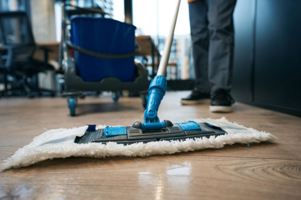 spotless cleaning | someone mopping a floor